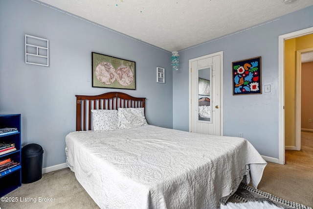 carpeted bedroom featuring baseboards and a textured ceiling