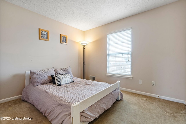 bedroom featuring light carpet, visible vents, a textured ceiling, and baseboards