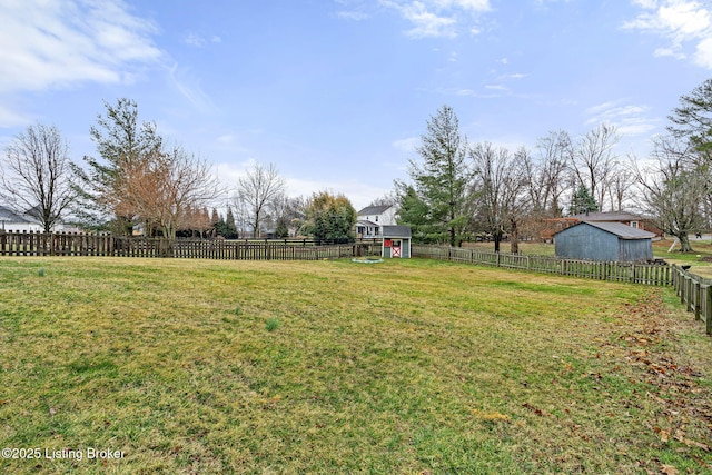 view of yard with a fenced backyard, a storage unit, and an outdoor structure