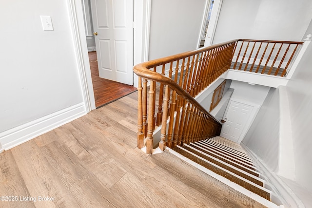 stairs with baseboards and wood finished floors