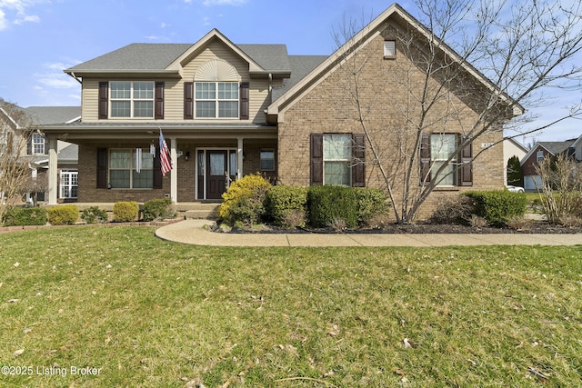 view of front of property with brick siding, covered porch, and a front lawn