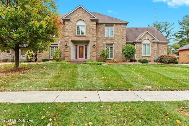 traditional home with brick siding and a front lawn