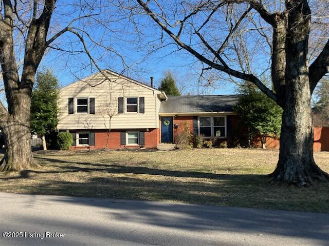 split level home with a front yard and fence