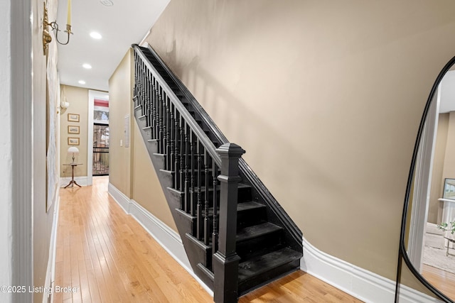 stairway featuring recessed lighting, baseboards, and hardwood / wood-style flooring