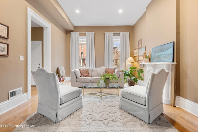 living room with recessed lighting, wood finished floors, visible vents, and baseboards