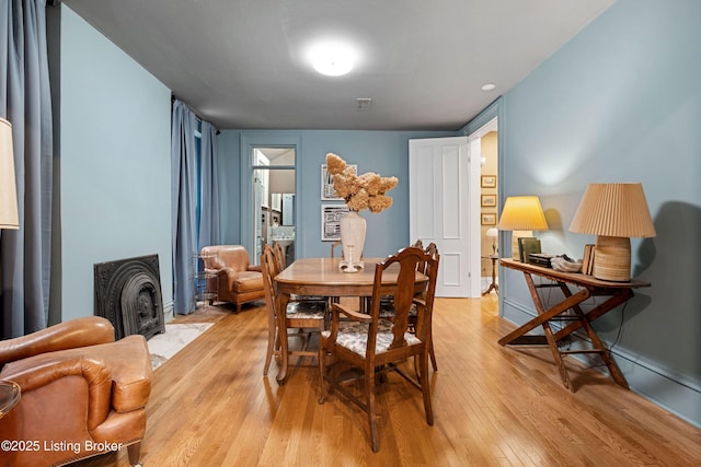 dining area featuring light wood finished floors and visible vents