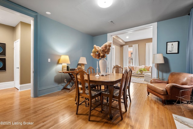 dining room with visible vents, baseboards, and light wood finished floors