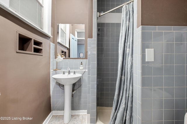 bathroom with decorative backsplash, tile walls, and a tile shower