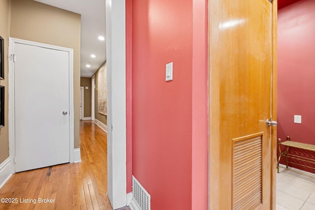 hall with visible vents, recessed lighting, baseboards, and wood finished floors