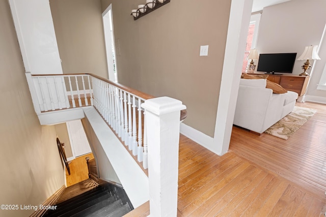 staircase featuring baseboards and wood-type flooring