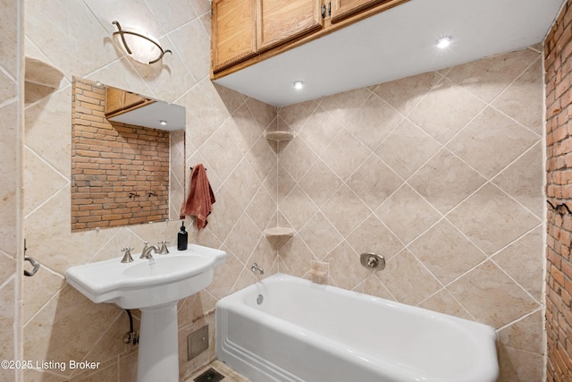 full bath with tile walls and a sink