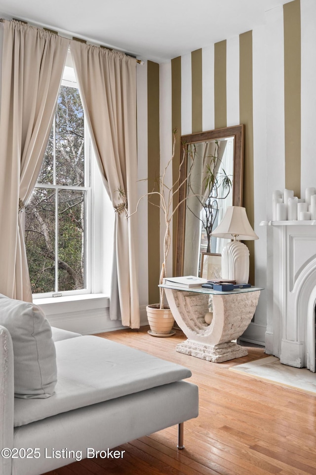 living area featuring wallpapered walls and hardwood / wood-style floors