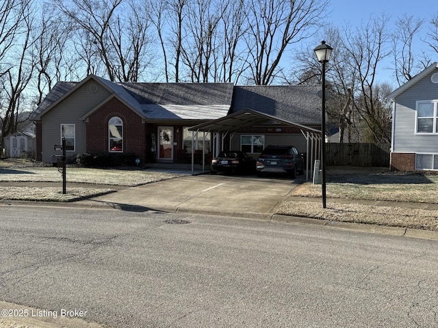 ranch-style home featuring brick siding, concrete driveway, roof with shingles, and fence