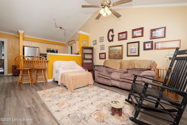 living room with a ceiling fan, high vaulted ceiling, wood finished floors, and ornamental molding