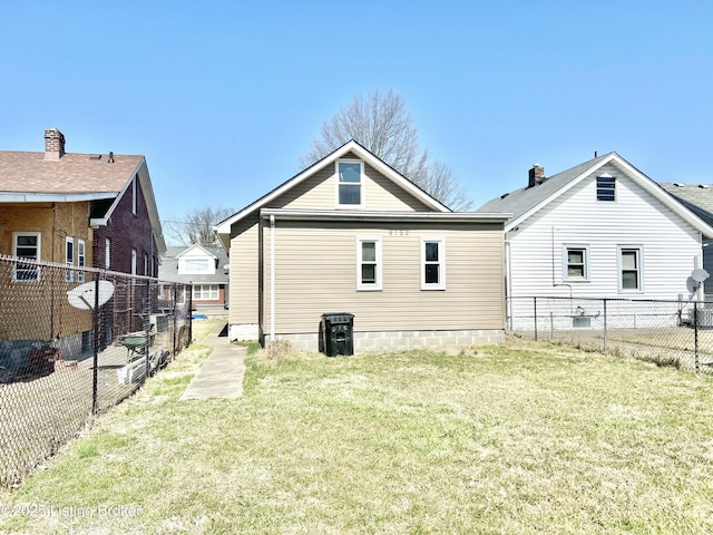 rear view of house featuring a yard and a fenced backyard