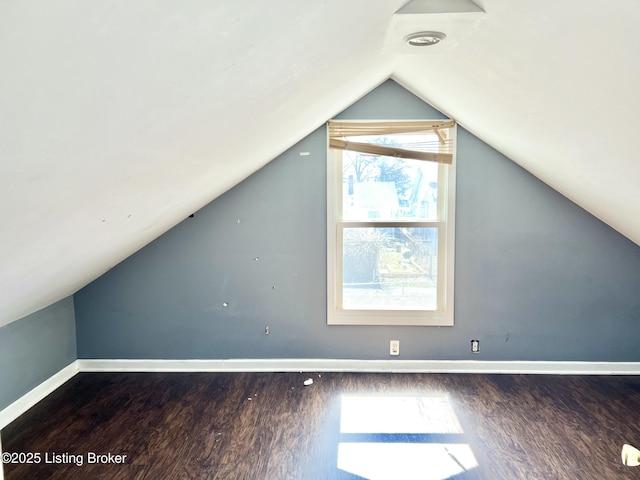 additional living space with lofted ceiling, baseboards, and wood finished floors