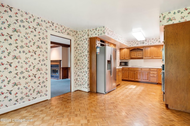 602 Club Ln, Louisville, KY 40207 - kitchen featuring stainless steel refrigerator with ice dispenser, wallpapered walls, light countertops, brown cabinets, and cooktop