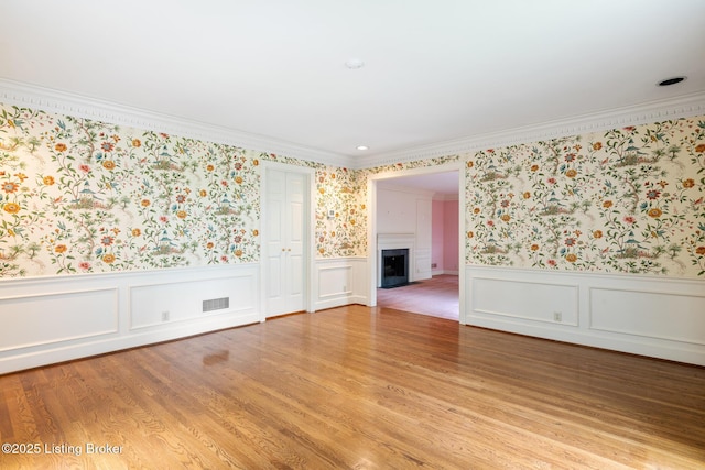 602 Club Ln, Louisville, KY 40207 - unfurnished room with wallpapered walls, ornamental molding, a fireplace, a wainscoted wall, and light wood-style floors