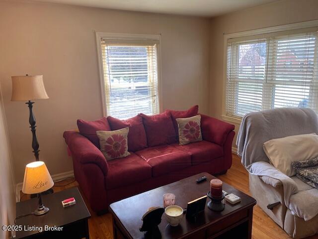 living area with baseboards and light wood finished floors