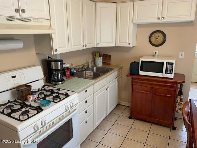 kitchen featuring under cabinet range hood, a sink, white cabinetry, white appliances, and light countertops