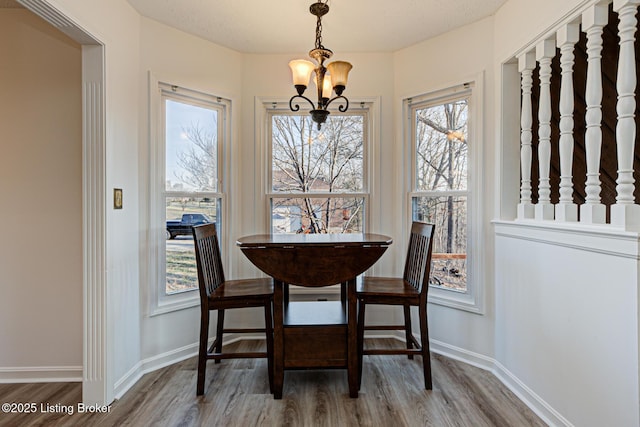 dining room featuring baseboards, an inviting chandelier, and wood finished floors