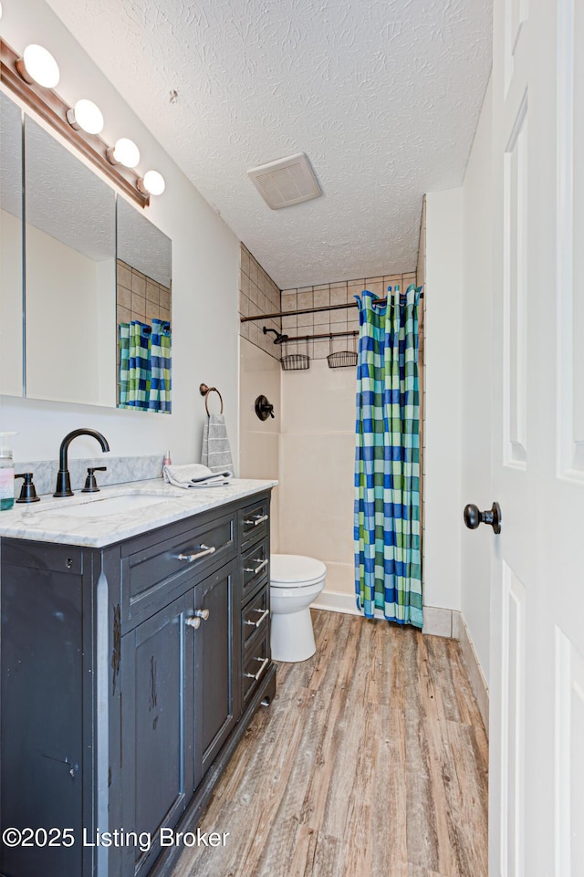 full bathroom featuring a shower with curtain, toilet, wood finished floors, and vanity