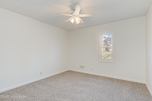 empty room with visible vents, baseboards, carpet floors, a textured ceiling, and a ceiling fan