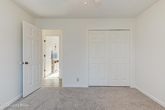 unfurnished bedroom with a closet, baseboards, and carpet