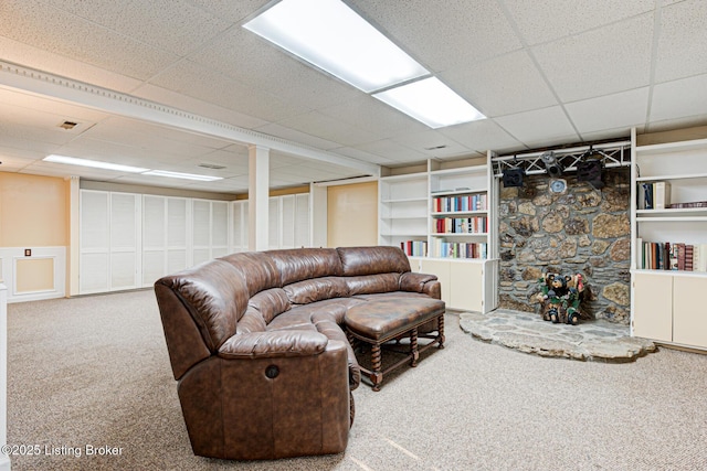 living area with carpet flooring, a paneled ceiling, and built in features