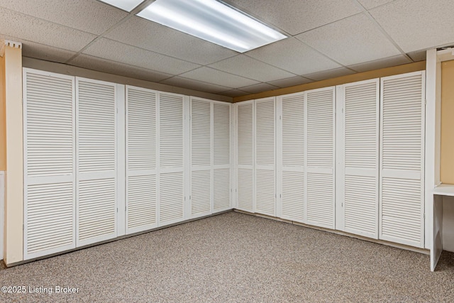 basement featuring carpet flooring and a drop ceiling