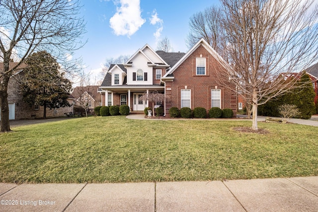 traditional home with brick siding, covered porch, and a front lawn