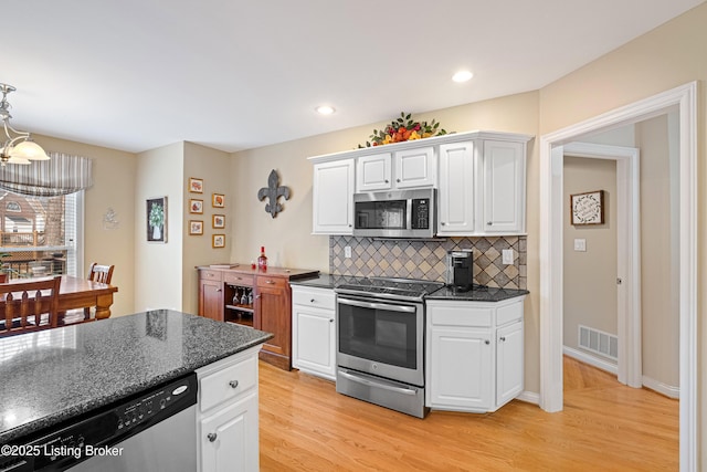 kitchen featuring white cabinetry, visible vents, light wood finished floors, and stainless steel appliances