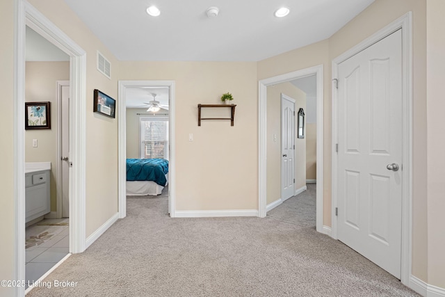 hall with recessed lighting, visible vents, light colored carpet, and baseboards