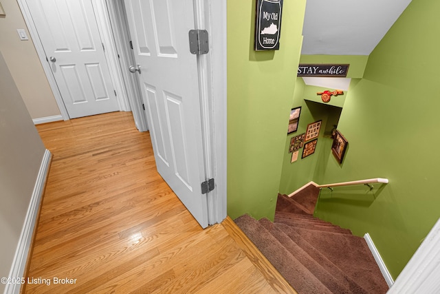 hallway featuring stairway, baseboards, and wood finished floors