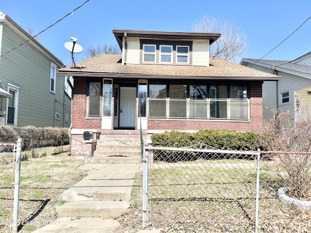 bungalow featuring brick siding, covered porch, and fence