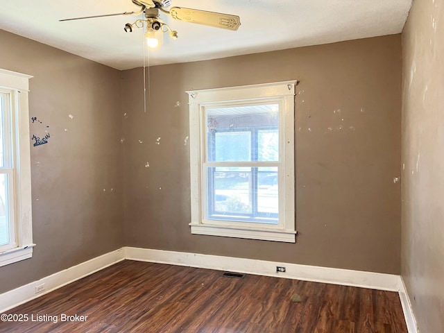 empty room featuring visible vents, ceiling fan, baseboards, and wood finished floors