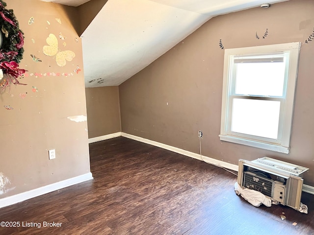 additional living space with baseboards, lofted ceiling, and wood finished floors