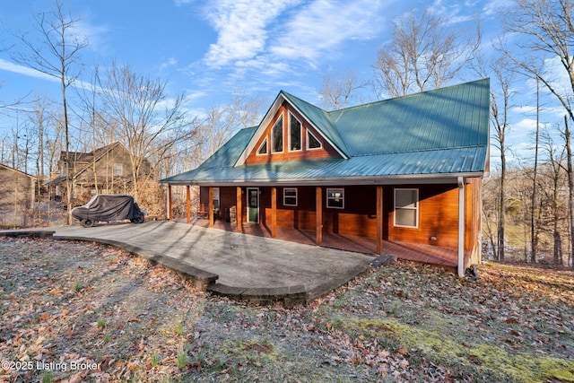 rear view of house with metal roof and covered porch