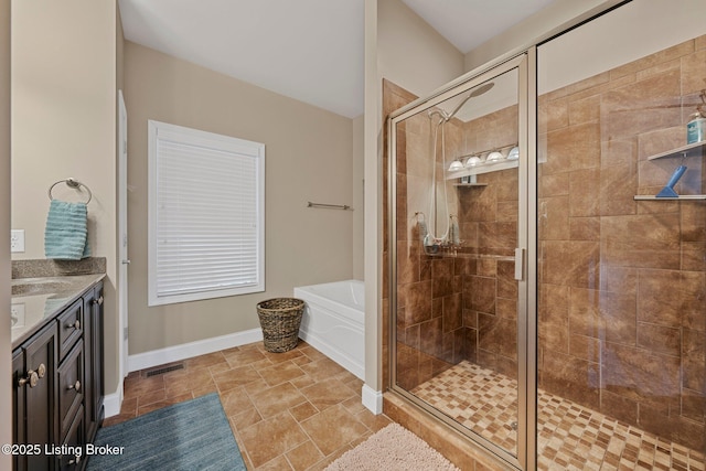 bathroom featuring visible vents, a garden tub, a stall shower, baseboards, and vanity