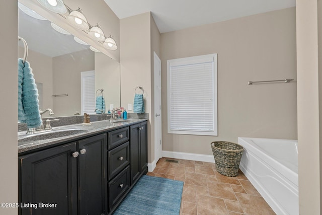 bathroom with double vanity, a bath, baseboards, and a sink