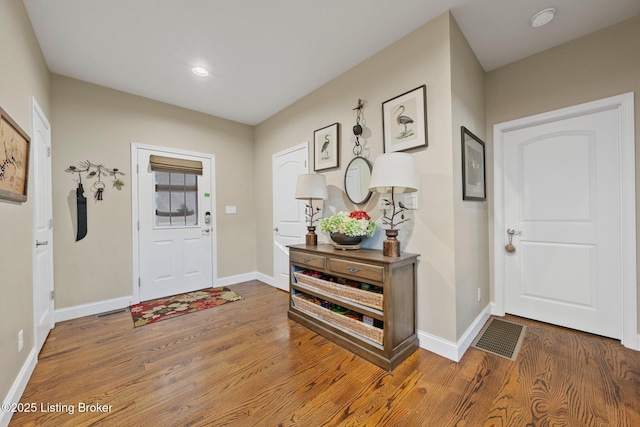 foyer entrance with visible vents, recessed lighting, baseboards, and wood finished floors