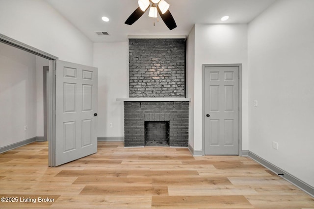 unfurnished living room with a ceiling fan, visible vents, light wood finished floors, baseboards, and a fireplace