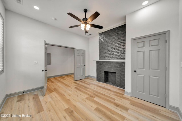 unfurnished living room with light wood-style flooring, recessed lighting, baseboards, a brick fireplace, and ceiling fan