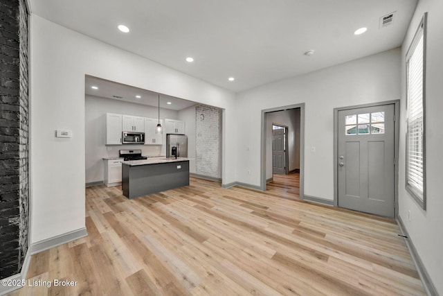 kitchen featuring visible vents, white cabinets, appliances with stainless steel finishes, and light wood-style floors