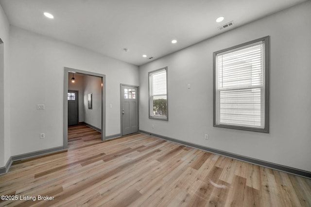 empty room with visible vents, recessed lighting, light wood-type flooring, and baseboards