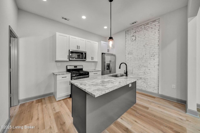 kitchen with white cabinets, visible vents, appliances with stainless steel finishes, and a sink