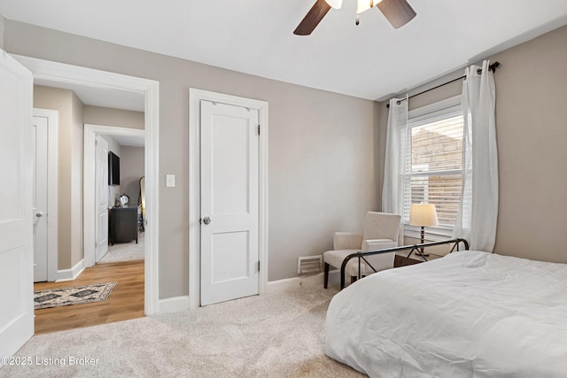 carpeted bedroom with baseboards, visible vents, and ceiling fan