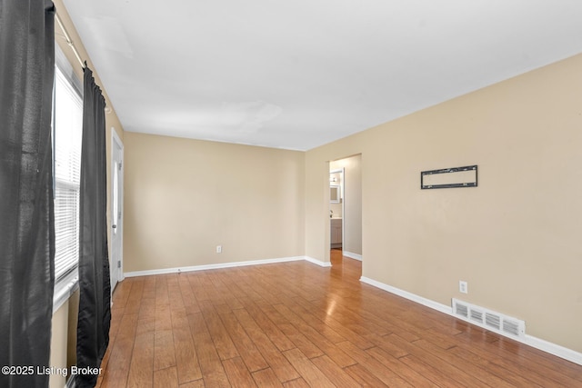 unfurnished room with baseboards, visible vents, and light wood finished floors