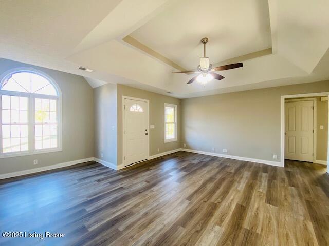 foyer featuring a raised ceiling, wood finished floors, and visible vents