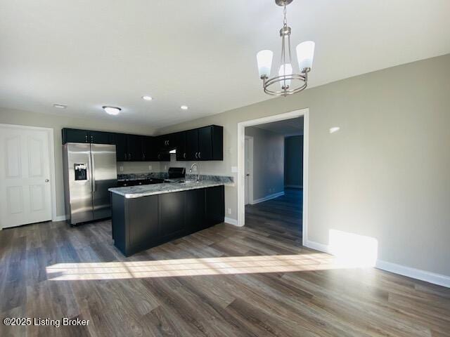 kitchen featuring dark cabinetry, stainless steel fridge, a peninsula, light countertops, and baseboards